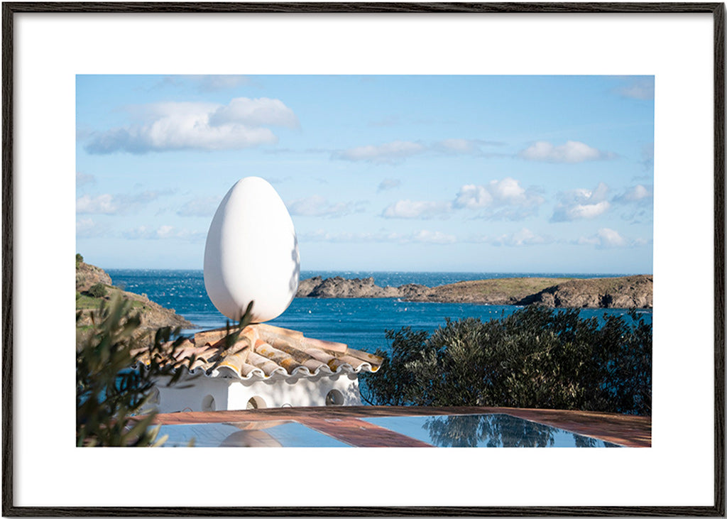 Landscape art featuring an egg sculpture by the sea