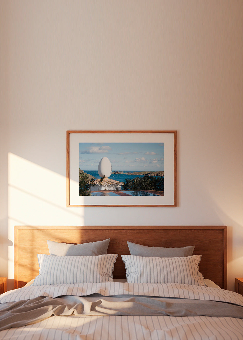 Landscape art featuring an egg sculpture by the sea