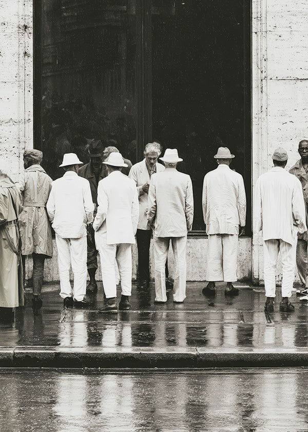 Black and white photo of men from the back in rain